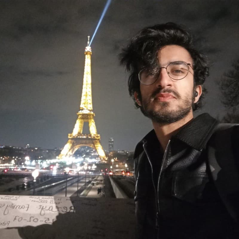 Taking a photo with the Eiffel Tower shining in the background.