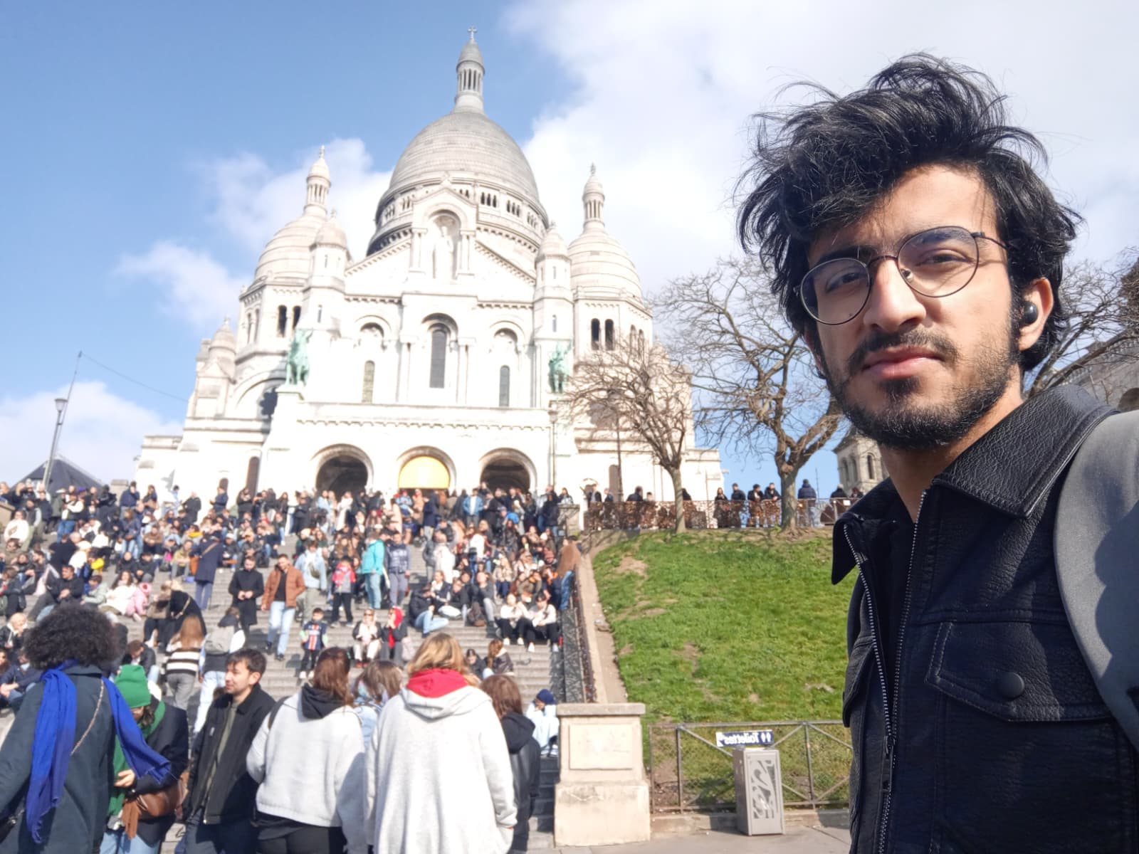 At Sacré-Cœur, surrounded by a huge crowd enjoying the sunny day.
