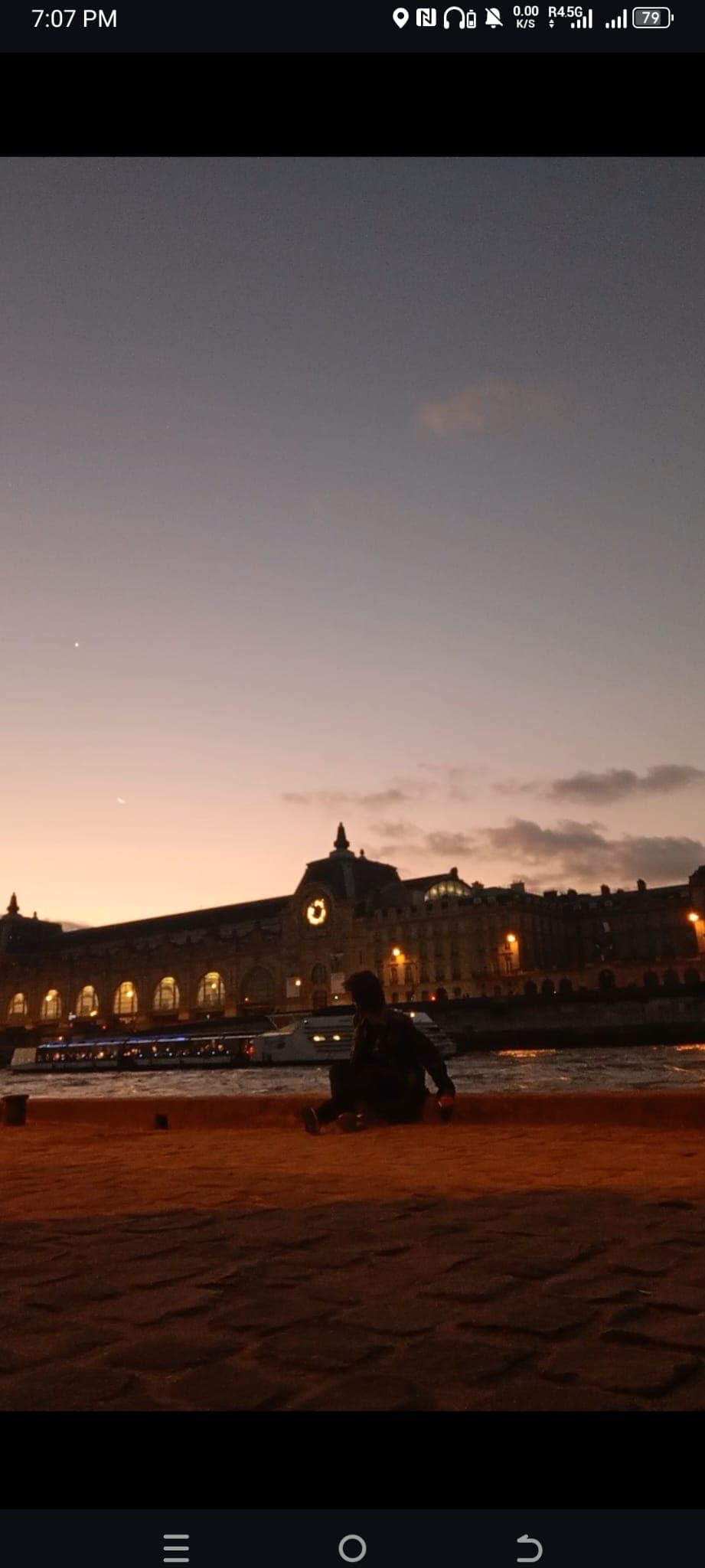Sitting by the Seine as the sky turned orange behind the Musée d'Orsay.
