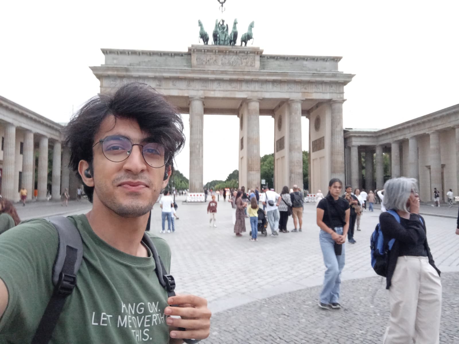Standing in front of the iconic Brandenburg Gate during the day.