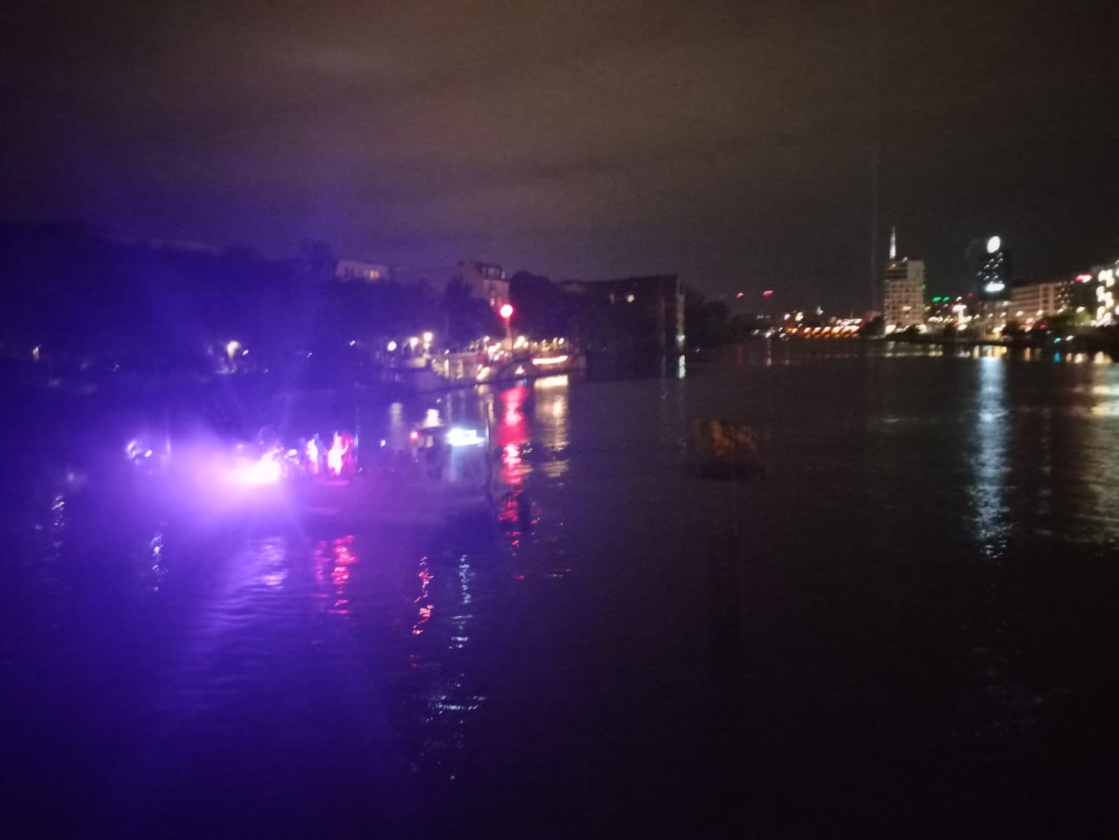 A party boat on the Spree River illuminated in purple lights.