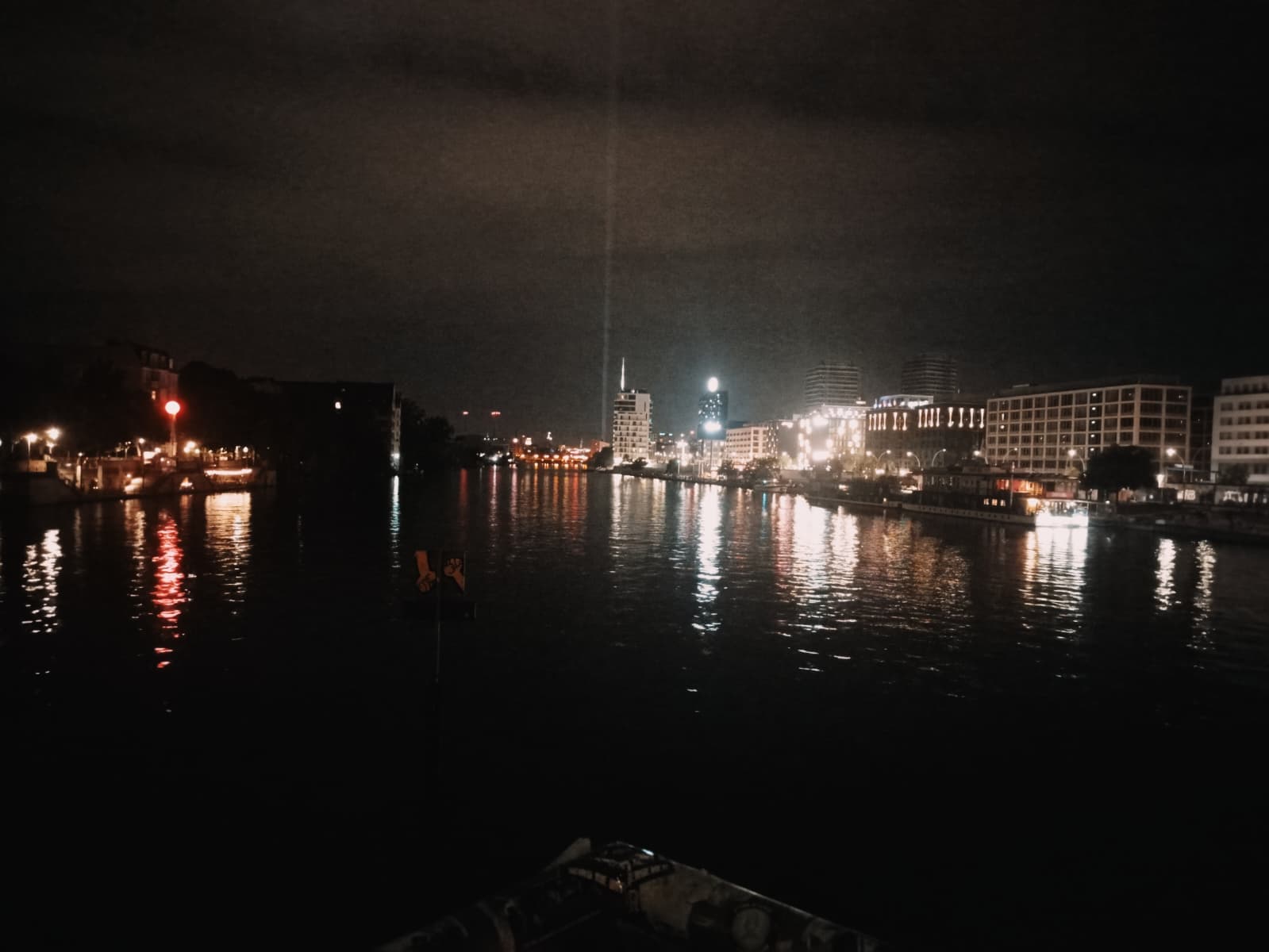 City lights reflecting on the Spree River at night.