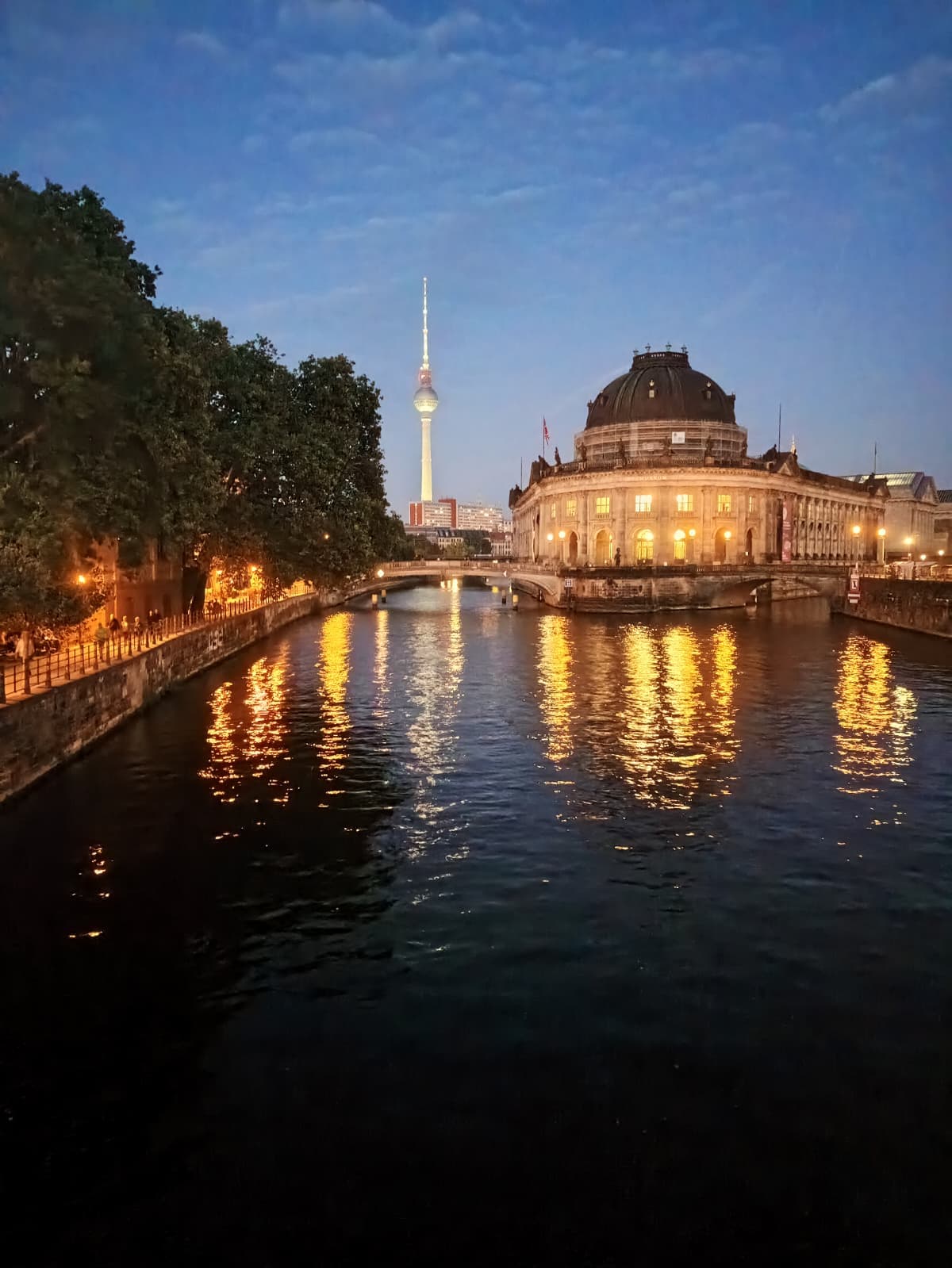 Twilight view of the Bode Museum with shimmering reflections.