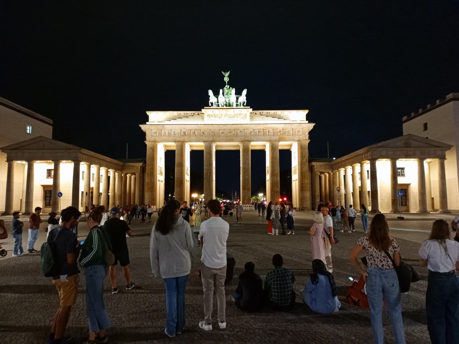 Night view of the Brandenburg Gate illuminated in golden light.