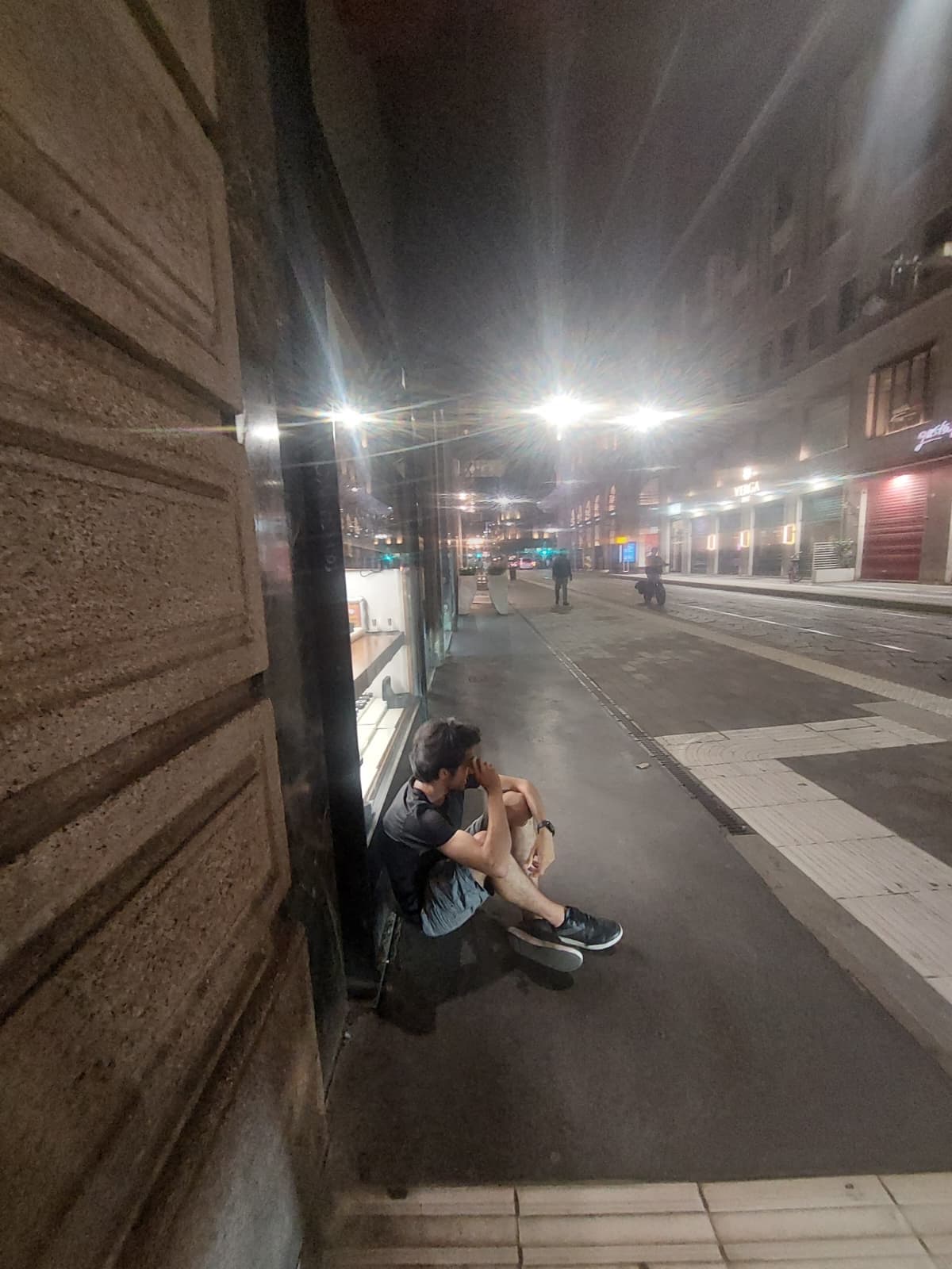 Sitting on the sidewalk late at night, watching the quiet streets of Milan.