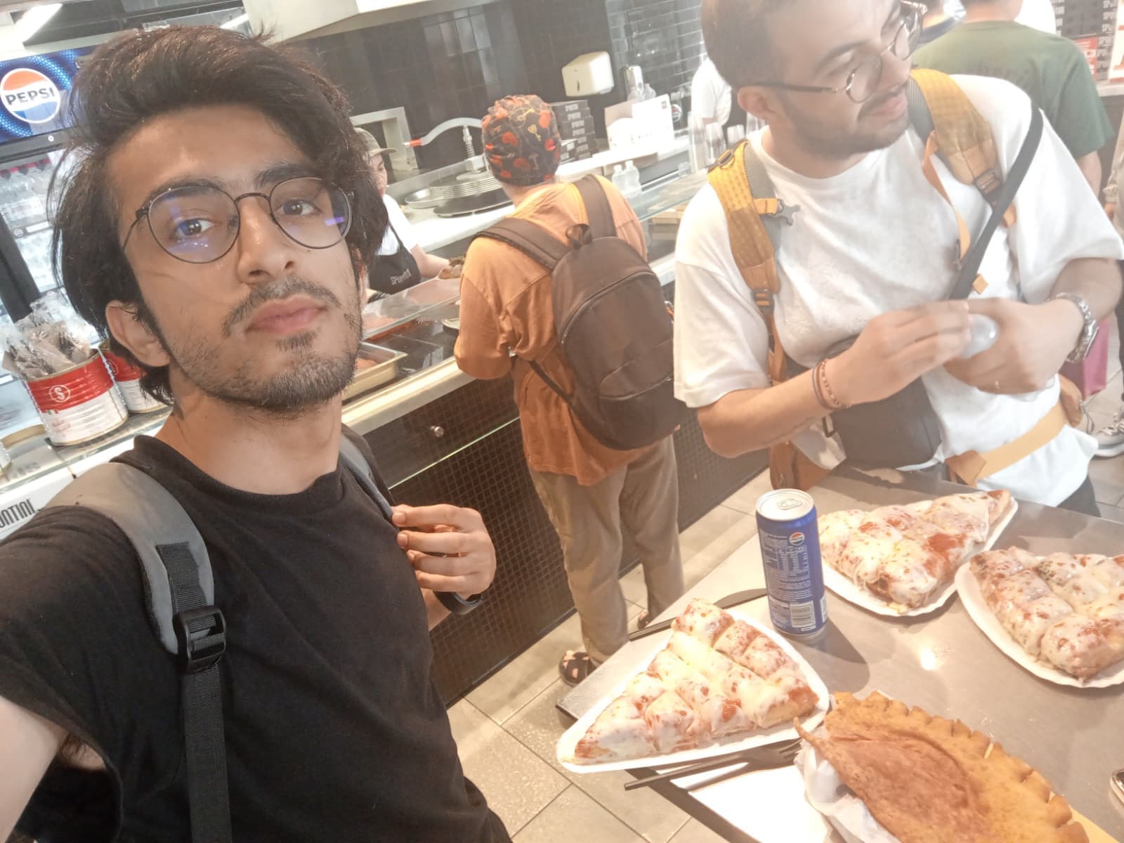 With friends at a pizza shop, ready to eat.