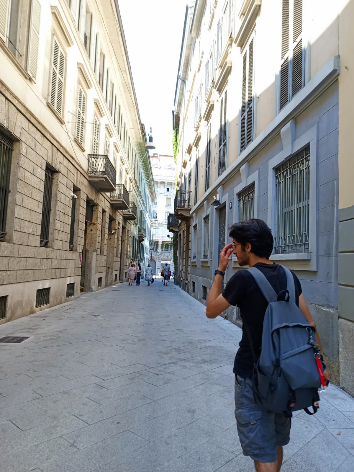Walking through a narrow Milan street in daylight.