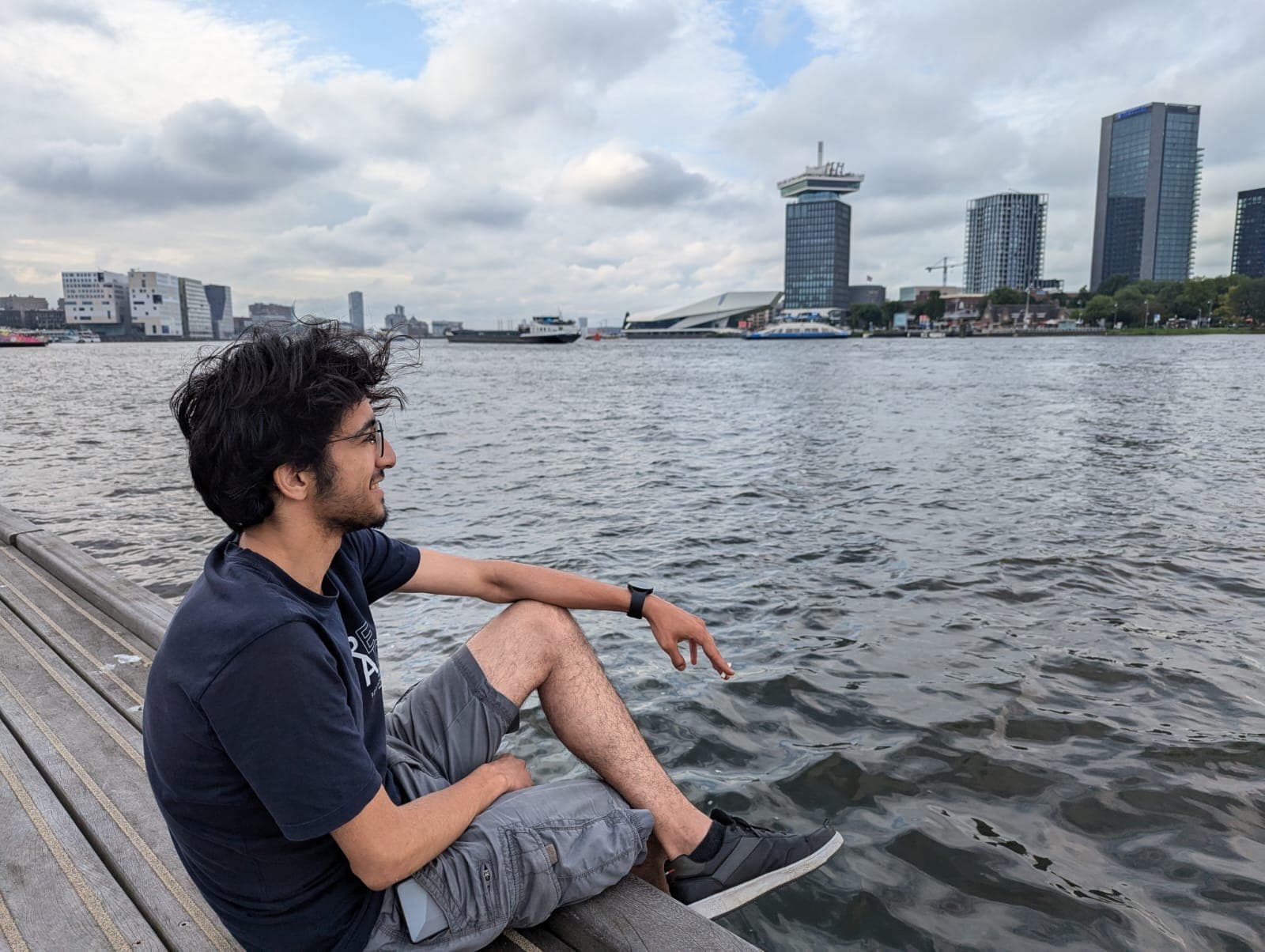 Relaxing by the river in Amsterdam, taking in the view of the modern skyline.