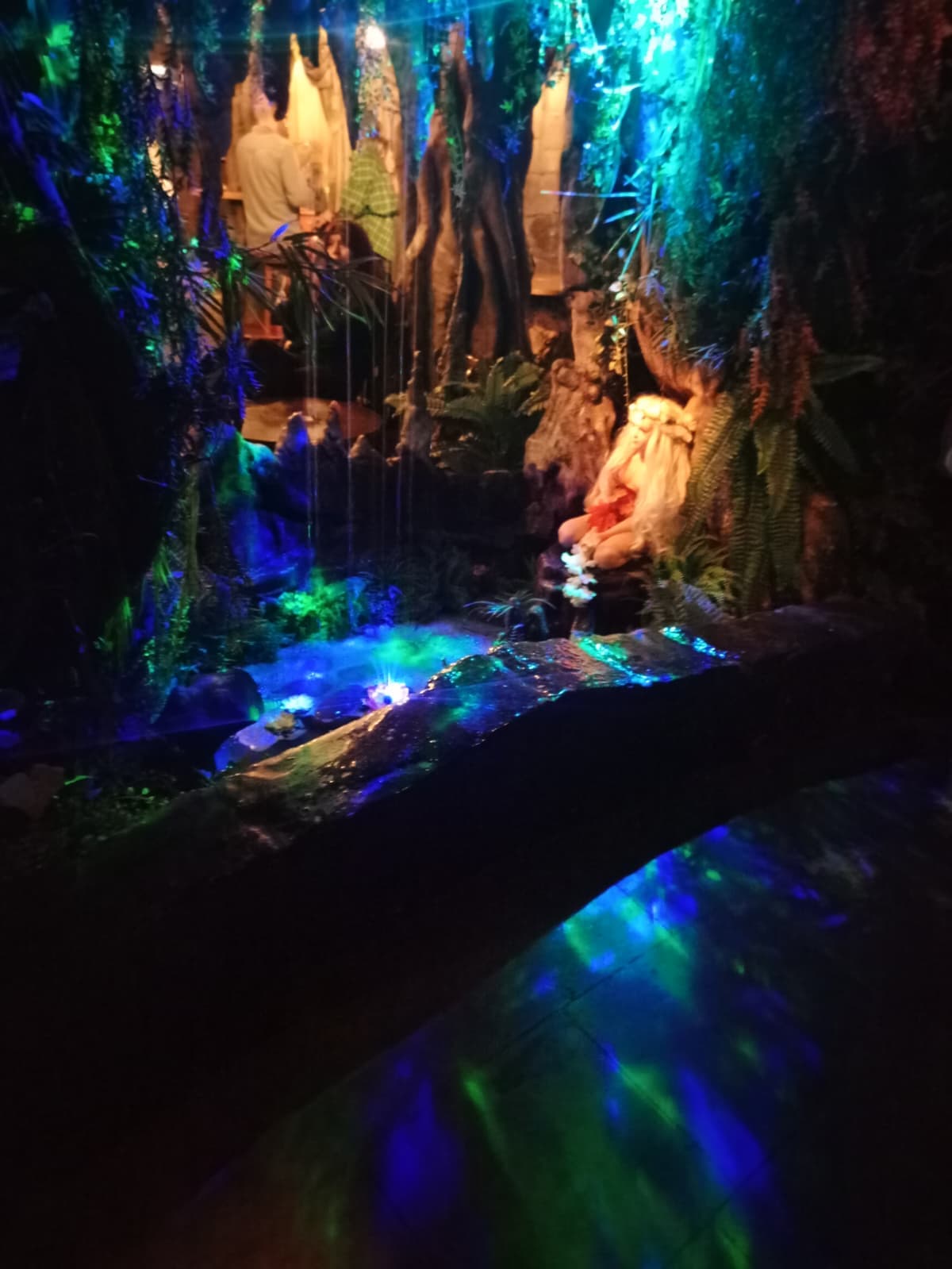 Inside a dimly lit fantasy-themed bar with glowing decorations.