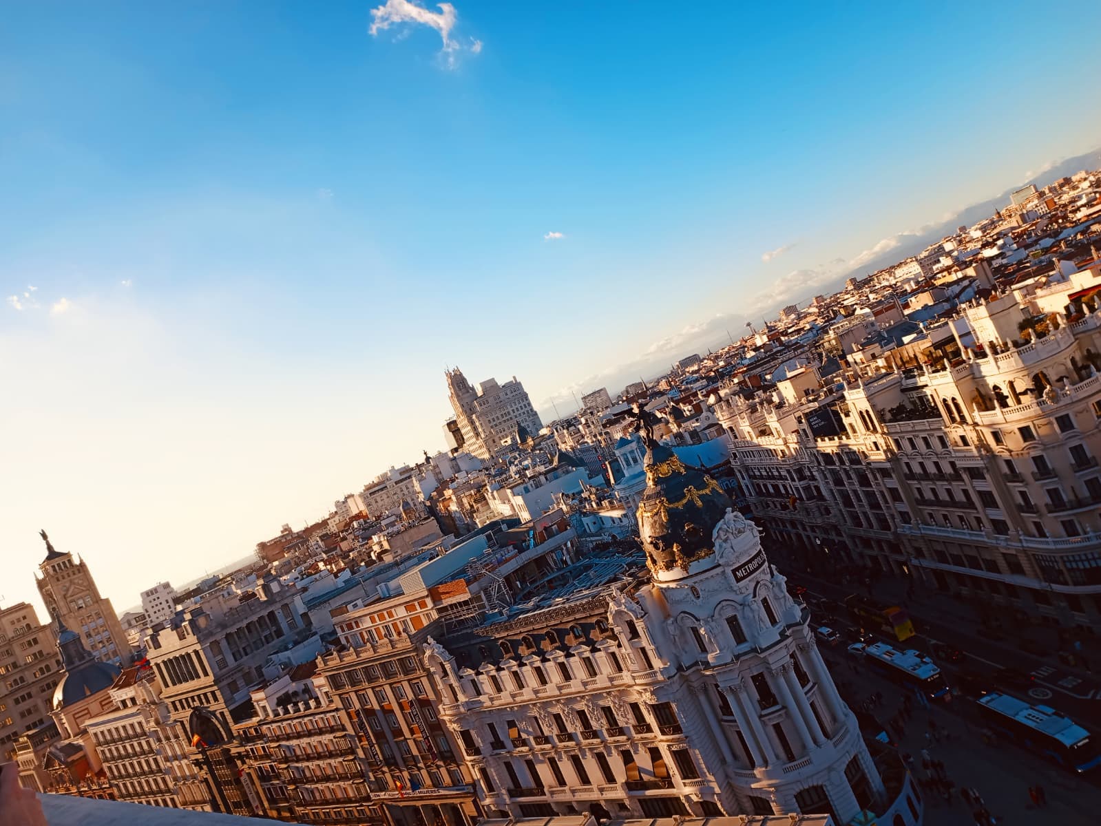 View over Gran Vía with the Metropolis building at golden hour.