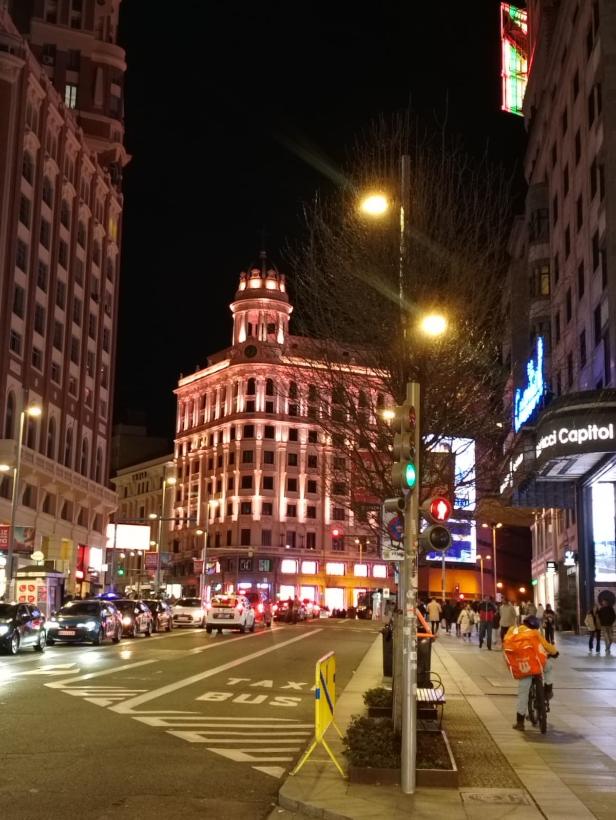 Walking through Gran Vía at night with the city lights all around.