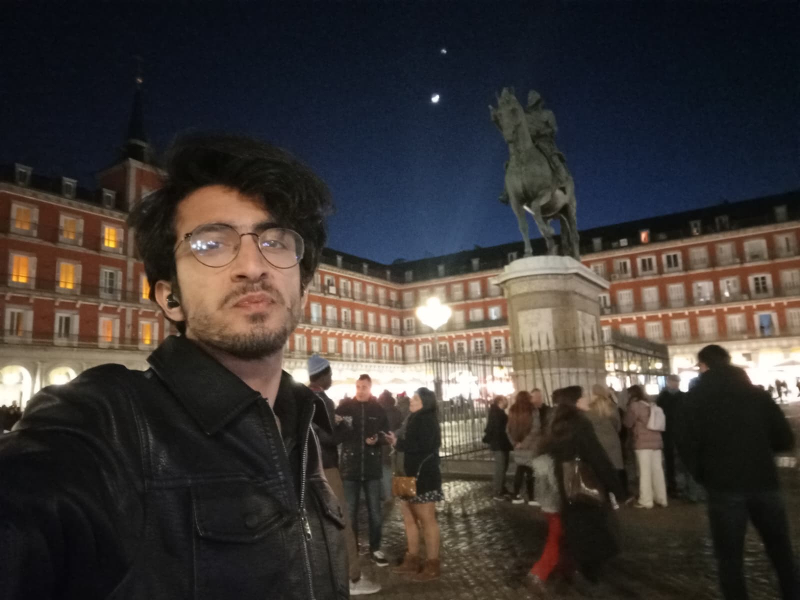 Nighttime at Plaza Mayor, surrounded by red-bricked historic buildings.